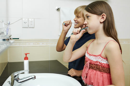 bambini puliscono denti per avere la corretta igiene orale